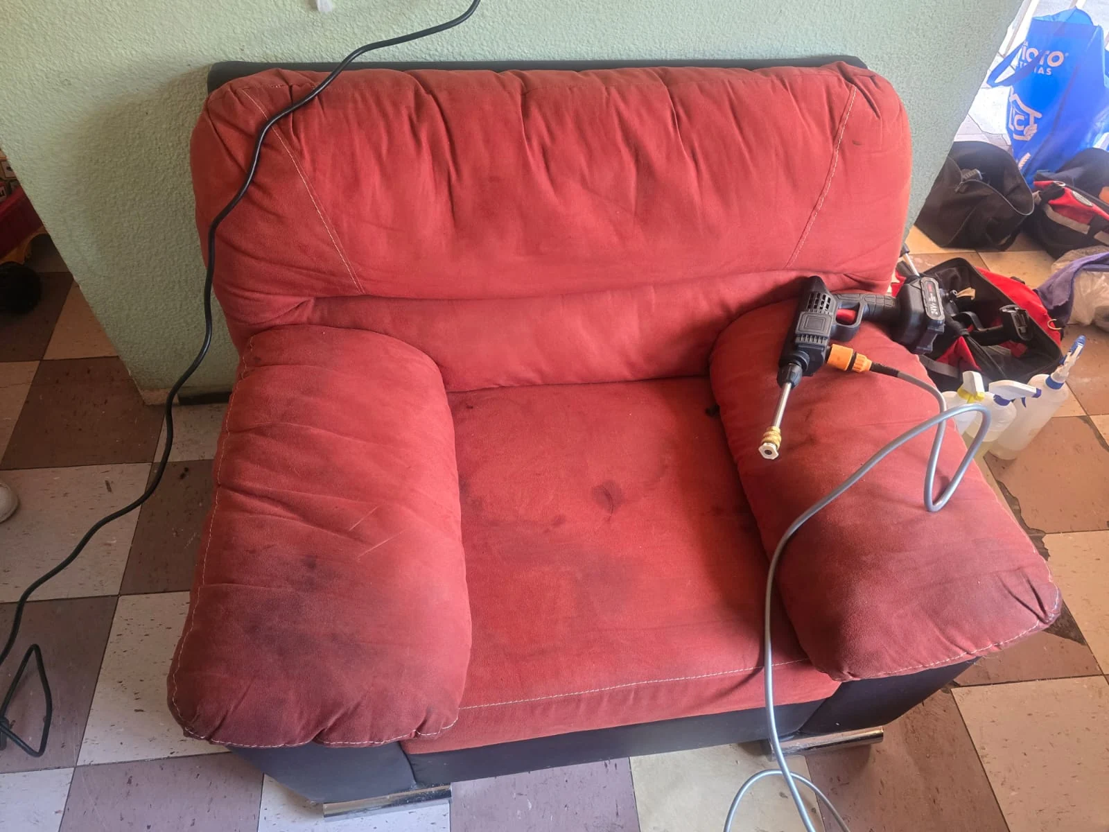 Sillón rojo con equipo de limpieza